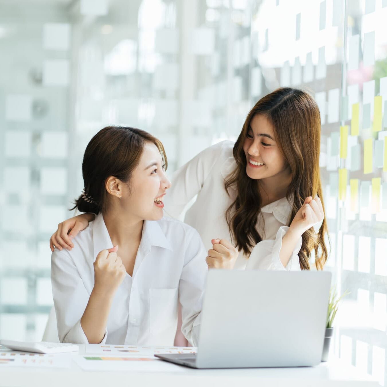 icf-credentialing-acc-exam-registration Two women look a laptop in an a calm office setting.